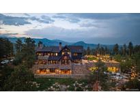 Expansive stone home with mountain views, outdoor living spaces, and professional landscaping at 34650 Sleeping Fox Trl, Evergreen, CO 80439