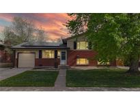 Charming brick home with solar panels, a well-maintained lawn, and mature tree at sunset at 821 Clarkson Ct, Denver, CO 80229