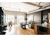 Bright living room featuring hardwood floors, plantation shutters, and modern furnishings at 1555 California St # 609, Denver, CO 80202