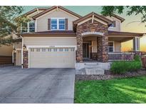 Charming two-story home with a stone-accented entrance and well-maintained lawn at 15310 E 108Th Way, Commerce City, CO 80022