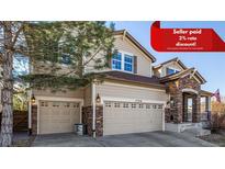 Inviting two-story home features a three-car garage, stone accents, neutral siding, and well-maintained landscaping at 15310 E 108Th Way, Commerce City, CO 80022