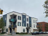 Modern apartment building with balconies and sleek, contemporary design, plus street and city signage at 336 E 1St Ave # 310, Denver, CO 80203
