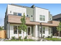 Modern townhome featuring a white tiled facade, wood accents, and professional landscaping at 2466 S Cherokee St, Denver, CO 80223