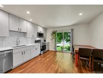 Bright eat-in kitchen features modern cabinetry, stainless steel appliances, and sliding glass doors at 6765 S Independence St, Littleton, CO 80128