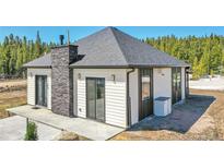 Charming single-story home with stone accents, gray roof, siding and a well-manicured lawn at 499 Silver Creek Rd, Idaho Springs, CO 80452