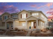 Charming townhome with stucco exterior and a cozy, inviting front porch with string lights at 11755 Crestop Way # C, Parker, CO 80138