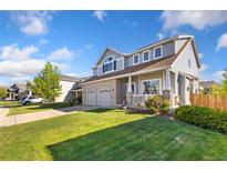 Charming two-story home with a well-manicured lawn and a two-car garage at 16478 Marion St, Thornton, CO 80602