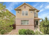 Charming two-story home featuring a brick facade and well-maintained landscaping, creating curb appeal at 368 Dallas St, Denver, CO 80230