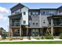 Beautiful townhouse with a black metal fence, landscaping, and a covered balcony at 6988 Ipswich Ct, Castle Pines, CO 80108