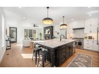 Bright, open kitchen with white cabinets, large island, and stainless steel appliances at 1695 N Zenobia St # 1, Denver, CO 80204