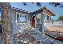 Charming home featuring a red front door and a cozy sunroom at 5723 Zephyr St, Arvada, CO 80002