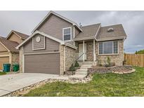 Charming two-story brick and siding home featuring an attached garage and landscaped front yard at 6610 Monaco Way, Brighton, CO 80602