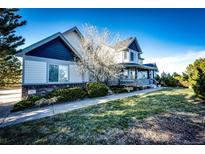 Charming two-story home with a well-manicured front yard and a covered front porch at 935 Green Gables Cir, Bennett, CO 80102