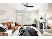 Bright living room featuring a brown leather sofa, decorative fireplace, and modern ceiling fan at 1767 N Washington St, Denver, CO 80203