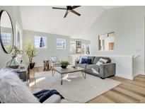 Bright living room with vaulted ceilings, hardwood floors, and ample natural light at 12961 Lafayette St # B, Thornton, CO 80241