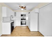 Bright kitchen features stainless steel appliances, white cabinets, and wood-look flooring at 6980 E Girard Ave # 204, Denver, CO 80224