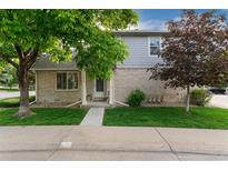 Charming home featuring a well-maintained lawn and an inviting entrance with beautiful mature trees at 1385 W 112Th Ave # D, Denver, CO 80234
