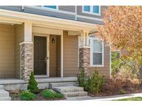 Inviting front door with brick accents and well-maintained landscaping offering charm and curb appeal at 3386 Valentia St, Denver, CO 80238