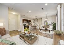 Open-concept living room seamlessly connects the kitchen, dining area, and comfortable seating, perfect for modern living at 3386 Valentia St, Denver, CO 80238