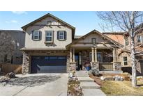 Charming two-story home with stone accents, inviting front porch, and well-manicured landscaping, creating excellent curb appeal at 10828 Valleybrook Cir, Highlands Ranch, CO 80130