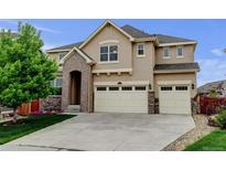 Beautiful two-story home showcasing a manicured lawn and a spacious three-car garage at 2454 Ambience Ln, Castle Rock, CO 80109