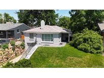 Charming single-story home featuring a stone chimney, lovely brickwork and lush green lawn at 2626 N Steele St, Denver, CO 80205