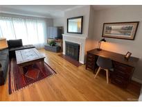 Inviting living room featuring a fireplace, hardwood floors, and a comfortable seating area at 2626 N Steele St, Denver, CO 80205
