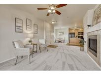 Open concept living room with fireplace, kitchen, and dining area at 16700 Las Ramblas Ln # O, Parker, CO 80134