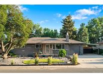 Charming brick home featuring landscaped front yard with lush trees, new roof, and convenient carport at 4100 Shaw Blvd, Westminster, CO 80031