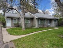 Charming single-story home with a well-manicured lawn and inviting walkway at 1950 Glen Shiel Dr, Lakewood, CO 80215