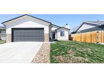 Beautiful exterior showcasing a well-kept lawn, a two-car garage, and stone accents at 4793 S Swadley St, Morrison, CO 80465