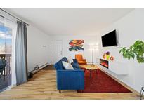 Inviting living room with modern fireplace, mounted TV, and stylish blue sofa and bright decor at 9240 W 49Th Ave # 317, Wheat Ridge, CO 80033