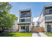 Modern three-story home with a balcony, landscaped front yard, and contemporary design at 1713 Grove St, Denver, CO 80204