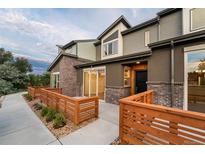 Modern two-story townhouse featuring a brick and stucco facade, private patios, and a nicely landscaped walkway at 12339 W 58Th Ct, Arvada, CO 80004