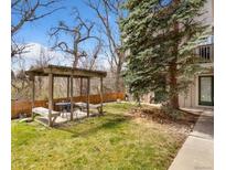 Landscaped backyard features a wooden pergola with seating area and lush lawn at 1607 Cottonwood Dr # 14, Louisville, CO 80027