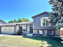 Charming two-story home with a well-manicured lawn, attached garage, and beautiful blue exterior at 4382 S Xenon St, Morrison, CO 80465