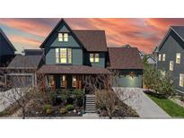 Inviting two-story home with a covered porch, professional landscaping, and an attached two-car garage at 9437 E 51St Dr, Denver, CO 80238
