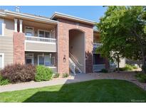 Brick and siding condo building with green lawn and manicured landscaping. Balconies and stairs provide entryways at 8481 W Union Ave # 2-201, Littleton, CO 80123