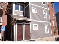 Multi-story condo building with gray siding, brick accents, and clearly marked unit entrances at 14353 E 1St Dr # 201, Aurora, CO 80011