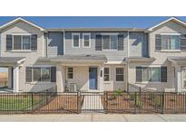 Charming townhome featuring a fenced yard, light brick and blue accent door at 27742 E 1St Ave, Aurora, CO 80018