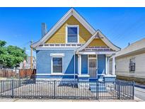 Charming blue two-story home featuring a unique yellow-shingled gable and decorative columns at 523 W 8Th Ave, Denver, CO 80204
