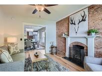 Inviting living room featuring a brick fireplace and an open view to the dining area at 2562 N Emerson St, Denver, CO 80205