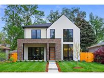 Modern two-story home with white siding, brick accents, and large windows, set on a green lawn at 1126 S Garfield St, Denver, CO 80210
