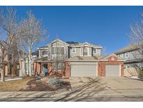 Two-story home with gray siding, brick accents, and a three-car garage at 415 S Snowmass Cir, Superior, CO 80027