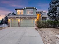 Two-story home featuring an attached two-car garage, brick accents, and manicured landscaping at 14497 Jason Dr, Westminster, CO 80023