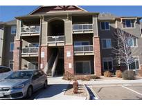 Exterior view of a light brown multi-story apartment building with parking at 804 Summer Hawk Dr # 9106, Longmont, CO 80504