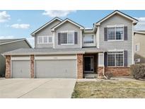 Charming two-story home featuring a three-car garage, brick accents, and lovely purple shutters at 10383 Coal Ridge St, Firestone, CO 80504