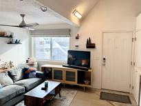 Bright living room with wood floors, comfy couch, and flat-screen TV at 8701 Huron St # 3-214, Thornton, CO 80260