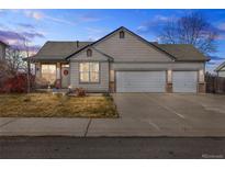 Charming single-story home featuring a three-car garage and a well-manicured front yard at 2321 Ance St, Strasburg, CO 80136