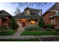 Charming home with stone accents, covered porch, and landscaped front yard at dusk at 3354 Vallejo St, Denver, CO 80211